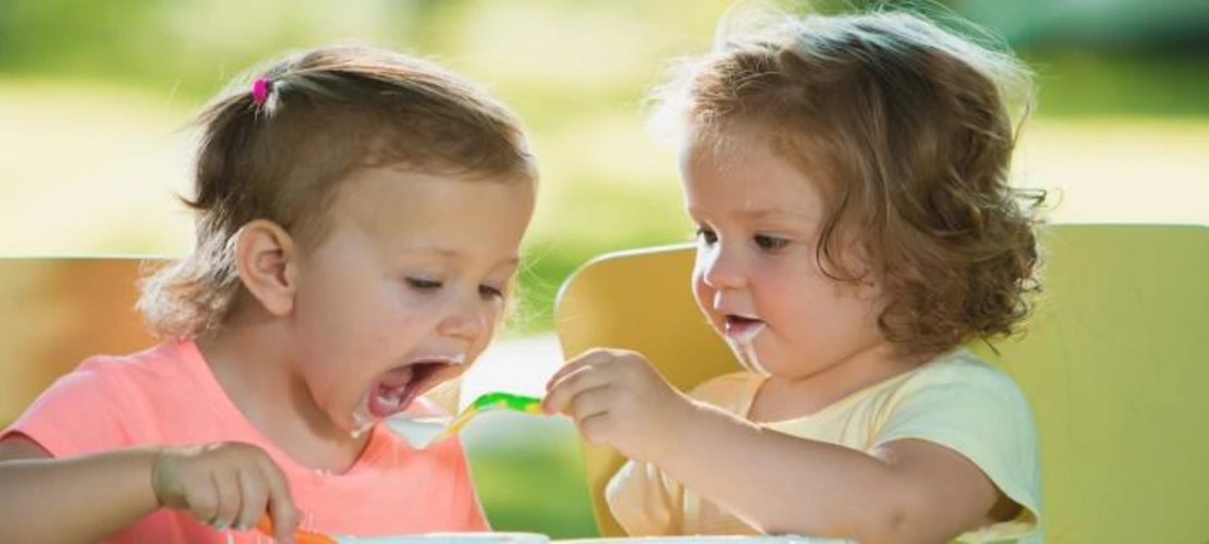 a child feeding another child
